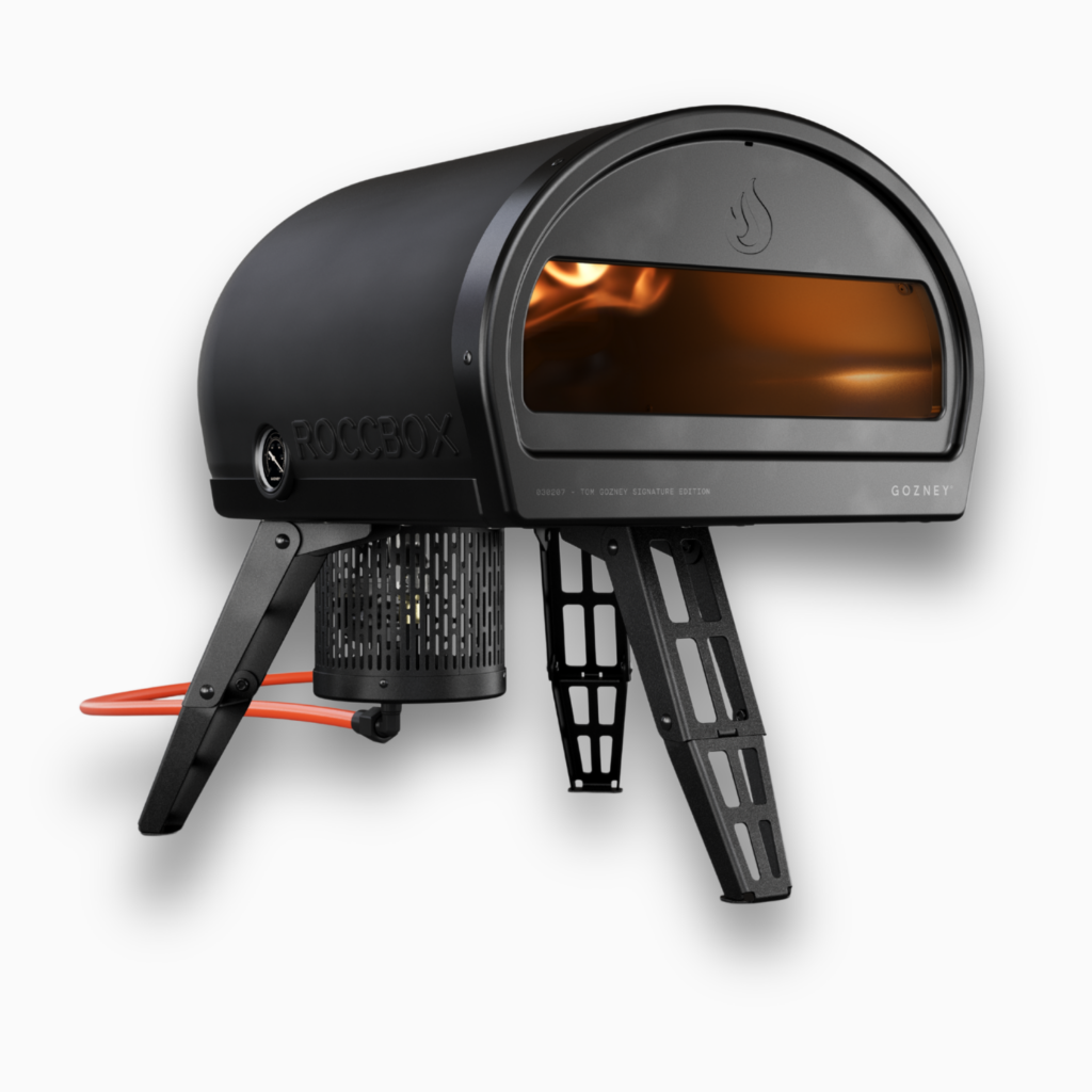 Schwarzer Gozney Roccbox Pizzaofen in Frontansicht mit beleuchtetem Garraum auf weißem Hintergrund
