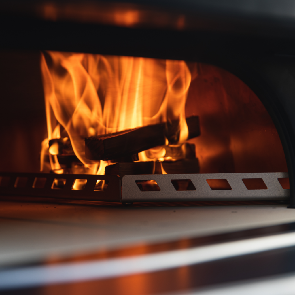 Brennendes Holzfeuer im Garraum eines Gozney Dome Pizzaofens in Nahaufnahme