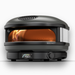 Gozney Arc Pizzaofen in Schwarz mit Sichtfenster, sichtbarer Flamme und digitaler Temperaturanzeige vor weißem Hintergrund