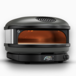 Gozney Arc Pizzaofen in Schwarz mit großem Sichtfenster, sichtbarer Flamme und digitaler Temperaturanzeige auf weißem Hintergrund