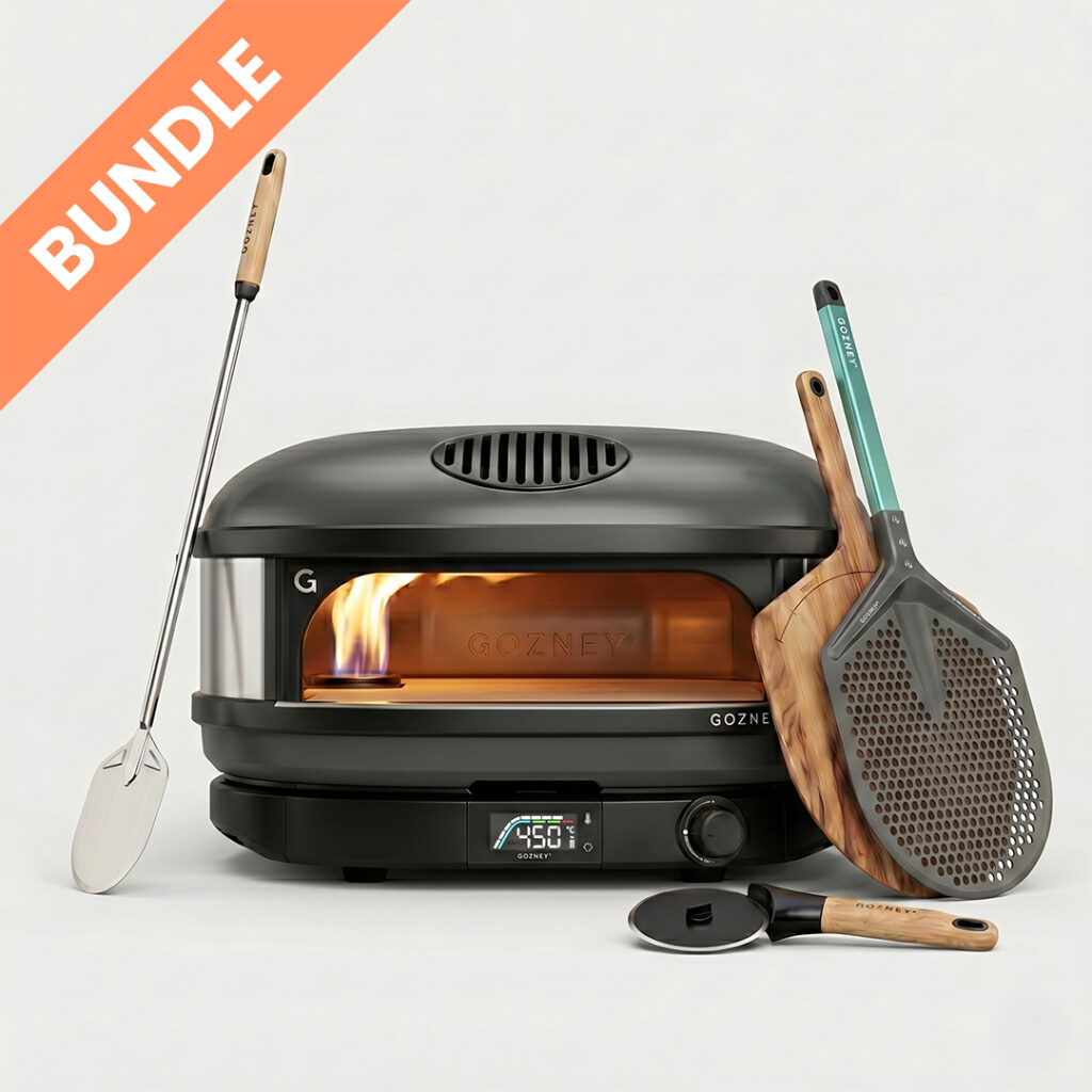 Gozney Arc XL Schwarz Pronto Starter Set Bundle – Großer Pizzaofen Nahaufnahme liegend mit sichtbarer Flamme, Metallschaufel, Holzpeeler und Pizzaschneider